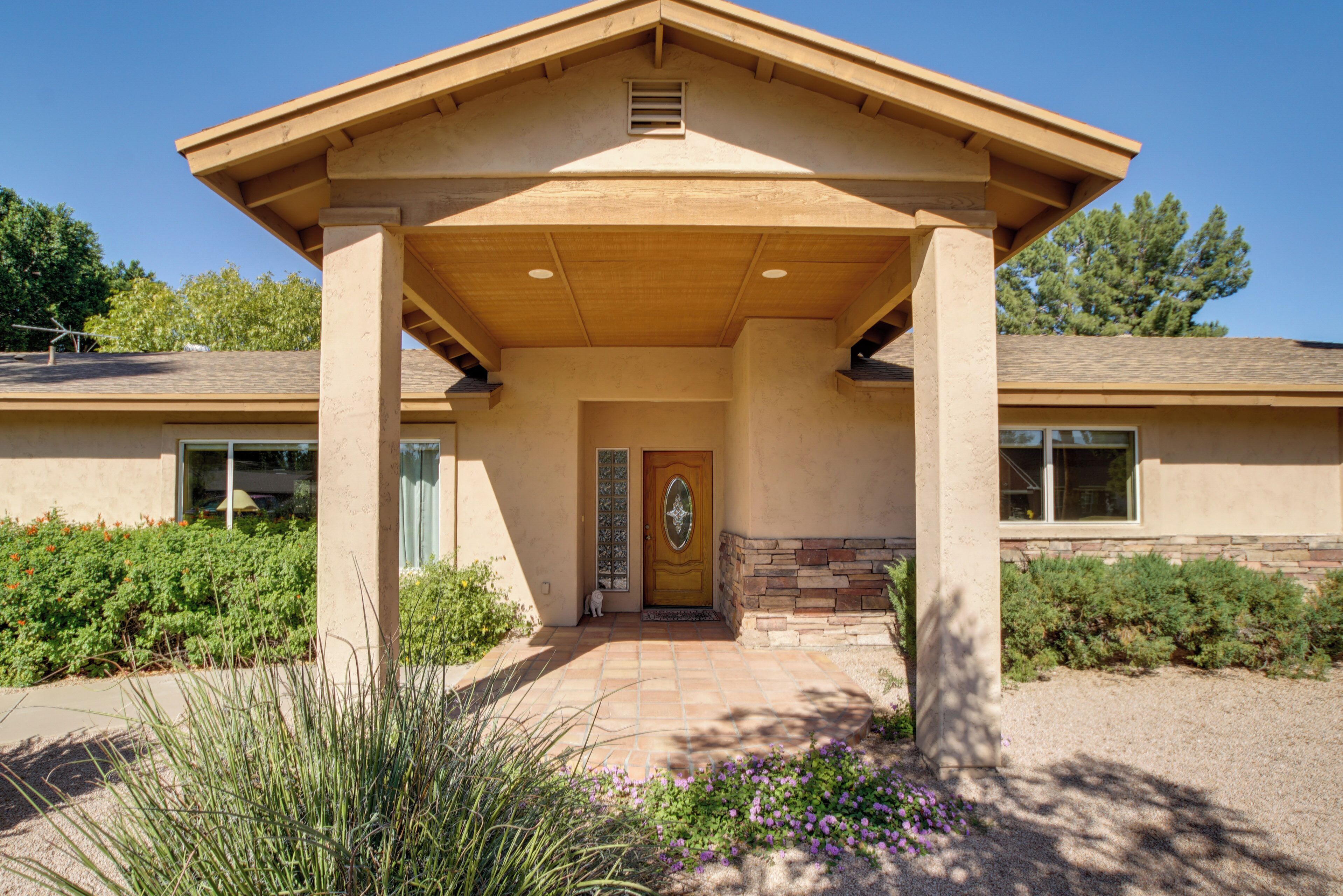 A building with a covered entrance, a wooden door, and a stone base.