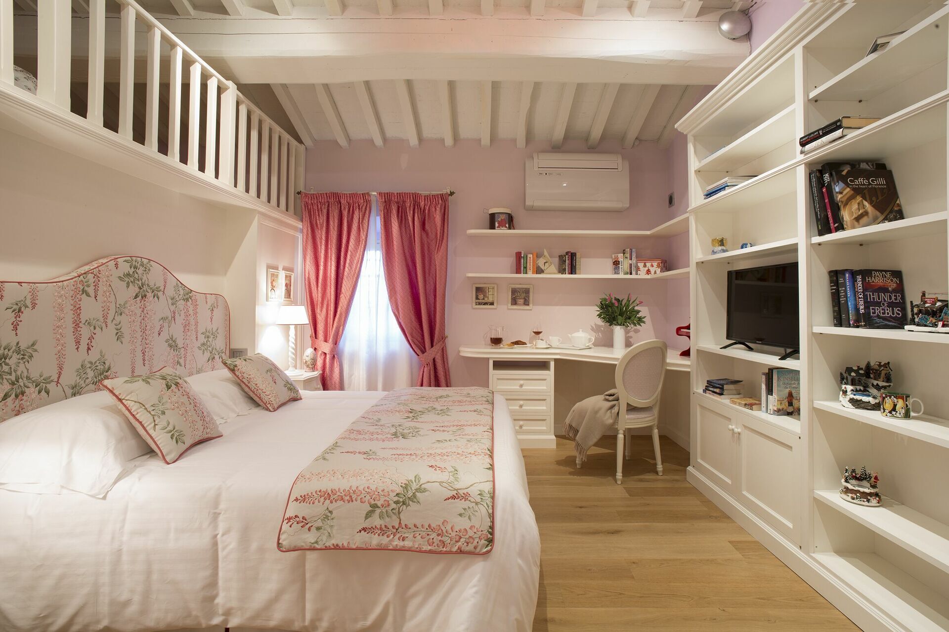 Ein Schlafzimmer mit einem Bett, einem Schreibtisch und einem Bücherregal.