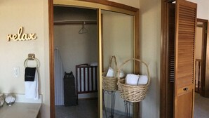 A room with a wooden door, a mirror, a towel rack, and a basket with towels. - Peaceful Riverfront Resort #2 (Three Rivers)