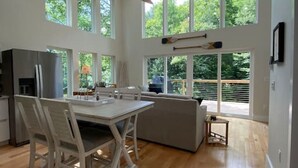 Una cocina amplia con comedor, ventanas grandes y ventilador de techo.