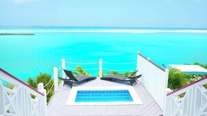 A deck with two lounge chairs overlooking a turquoise ocean and a small pool. - Ultimate Vacation in Paradise at BLU (Rolletown)