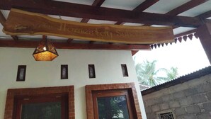 A rustic building with a wooden sign above the entrance, a brick fireplace, and a hanging light fixture.