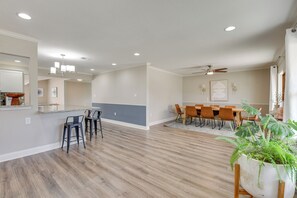A spacious living area with a dining table and chairs, a kitchen area with a countertop, and a large potted plant. - Spacious Fort Walton Beach Home ~ 2 Mi to Beach! (Fort Walton Beach)