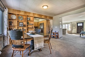 A dining area with a wooden table, chairs, and a buffet cabinet.