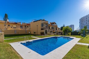 Un quartier résidentiel doté d’une piscine, d’une cour clôturée et d’un immeuble avec des balcons.