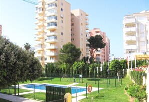 Un quartier résidentiel avec de grands immeubles, une piscine et des espaces verts bien entretenus.