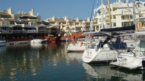 A marina with boats docked, buildings with balconies, and a clear sky. - Family-Friendly Apartment with Private Terrace, Shared Pool, A/C & Wi-Fi (Benalmádena)