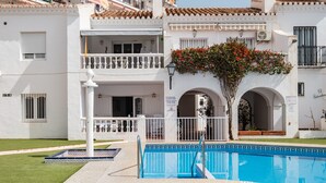 A white building with a pool, balconies, and a sign. - Bright and Spacious Apartment near Beach with Shared Pool, A/C & Wi-Fi (Nerja)