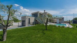 Une maison moderne dotée d’une piscine, d’un escalier et d’une cour clôturée.