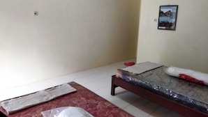 Una habitación con cama, una mesita y un cuadro colgado en la pared.