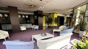 A modern lobby with white and light blue seating, a reception desk, and potted plants. - Caprioara Spa&Wellness Resort (Covasna)