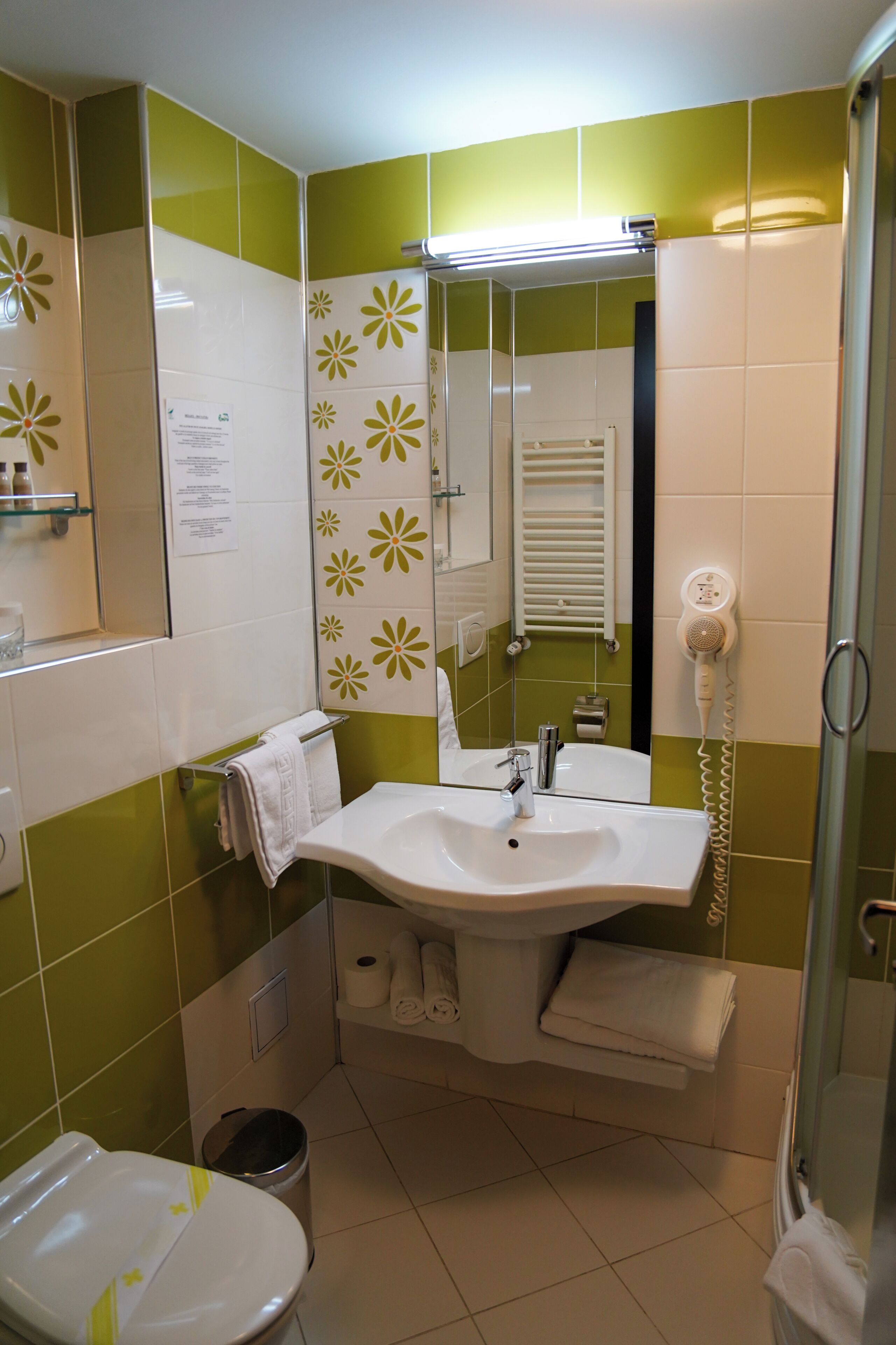 Ein Badezimmer mit Waschbecken, Spiegel, Handtuchhalter und Toilette.