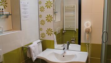 Ein Badezimmer mit Waschbecken, Spiegel, Handtuchhalter und Toilette.