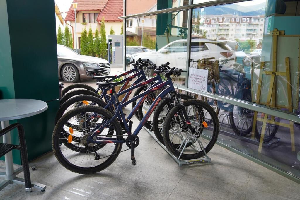A bicycle rental station with multiple bikes and a sign indicating rental prices.
