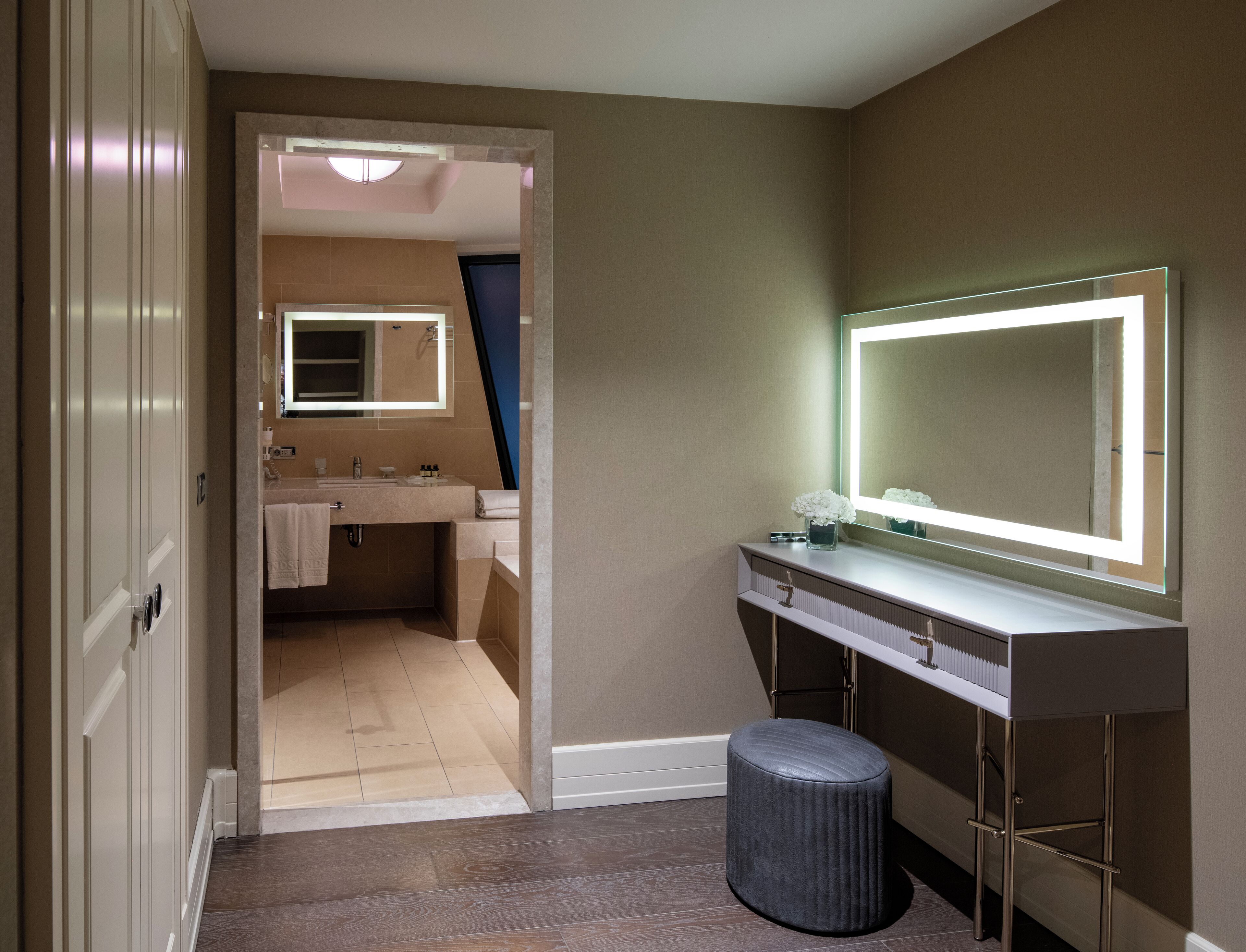 A modern bathroom with a vanity, mirror, and toilet.