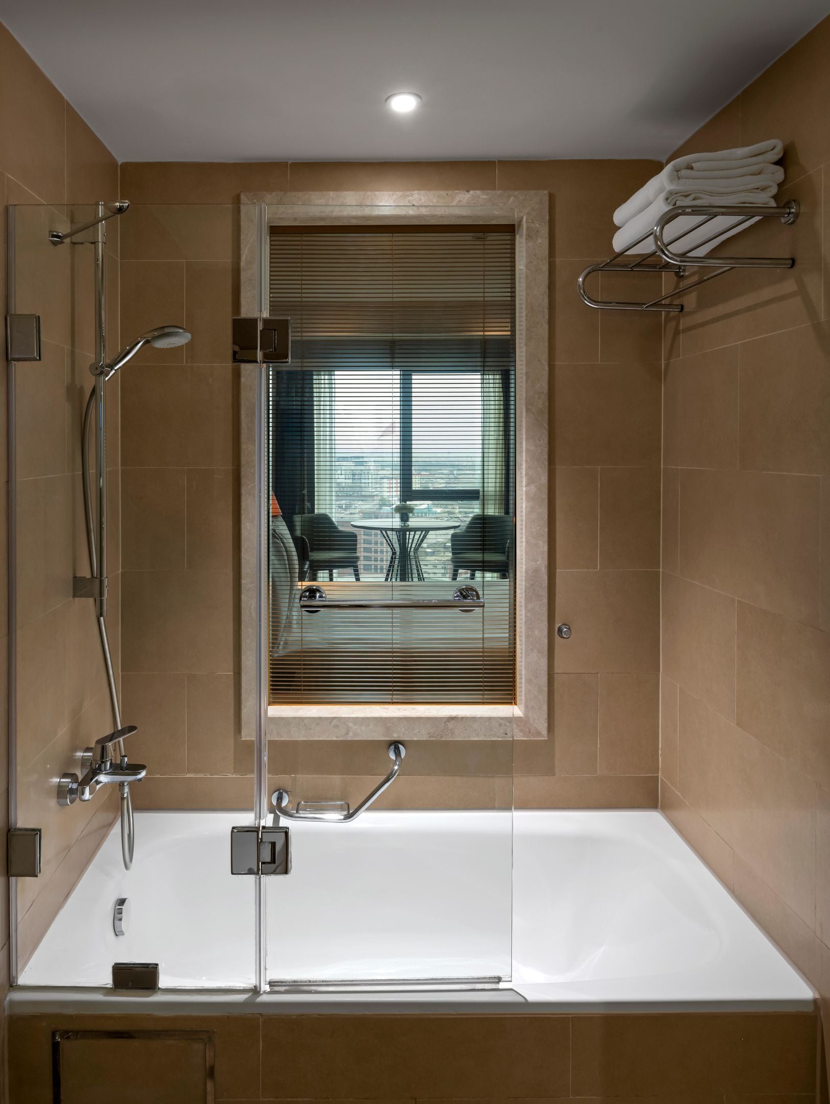 A modern bathroom with a bathtub, shower, and window.