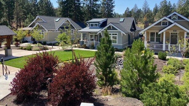 A residential area with multiple houses featuring gabled roofs and front porches. - Art Collector's Sophisticated NW Crossing Home (Bend)