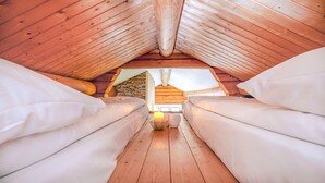 A cozy attic bedroom with two beds, a stone wall, and a skylight. - Topcamp Mosjøen - Helgeland (Vefsn)