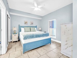 A bedroom with a bed, nightstands, a ceiling fan, and a window with blinds. - 🌊Beachfront Views-Top Floor-Majestic Beach 1-2314🌊 (Panama City Beach)