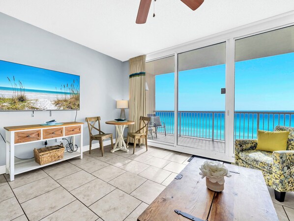 A balcony with a view of the ocean, a dining table, and a sofa with a cushion. - 🌊Beachfront Views-Top Floor-Majestic Beach 1-2314🌊 (Panama City Beach)