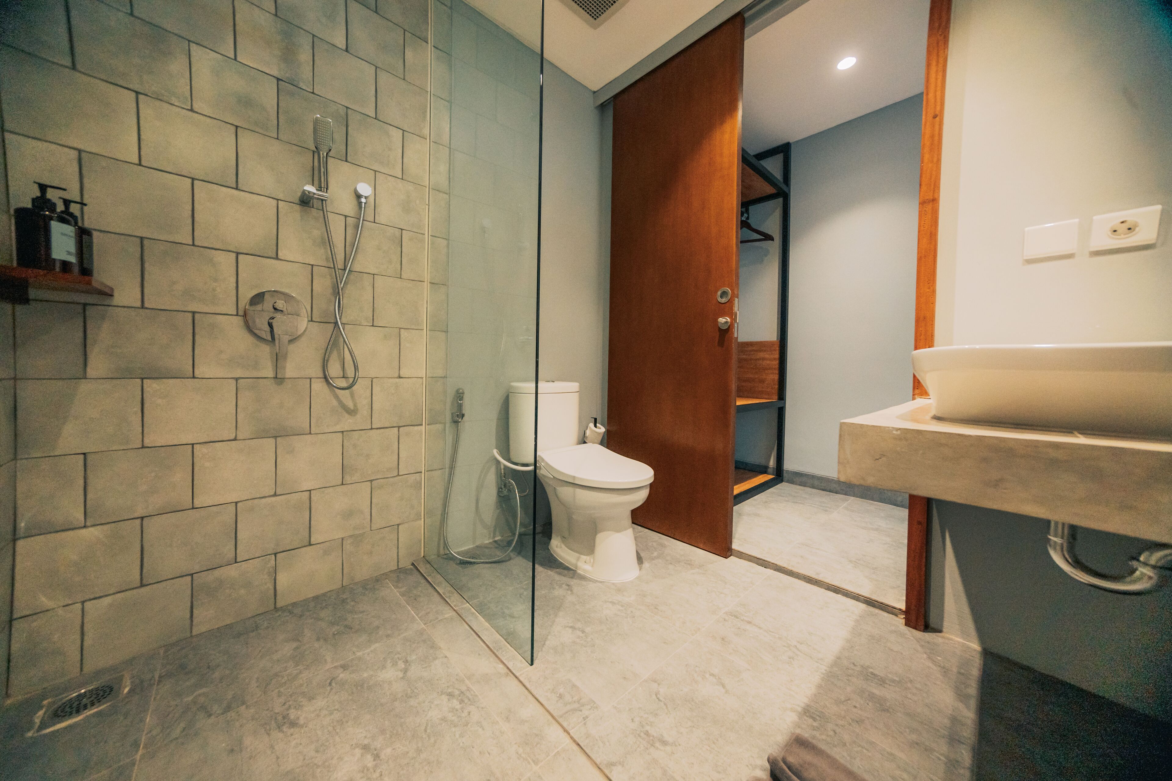 Een badkamer met een douche, toilet en wastafel.