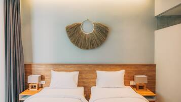Een hotelkamer met twee bedden, een houten hoofdbord, nachtlampen en een decoratief object aan de muur.