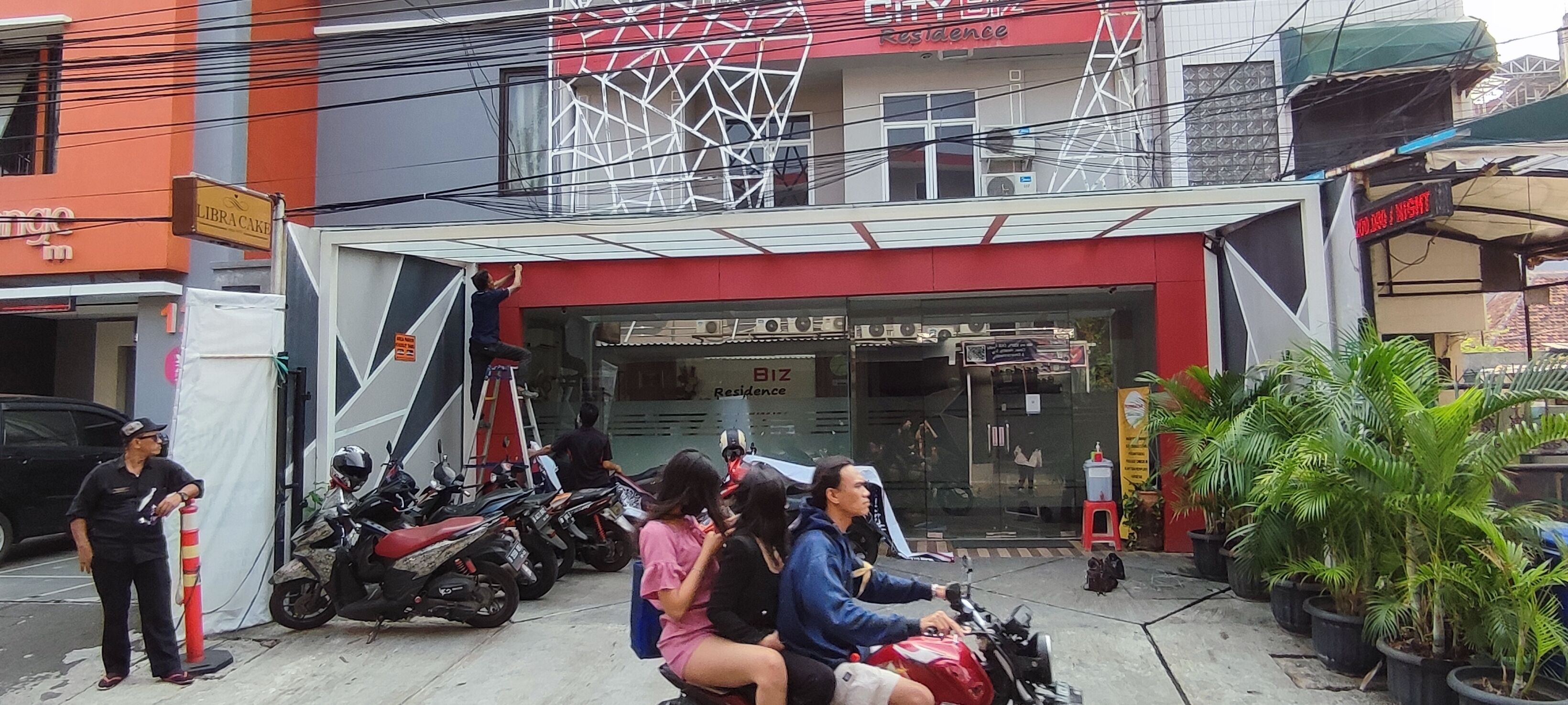 Un edificio de fachada roja con un cartel que dice "CITY SIZE Residence".