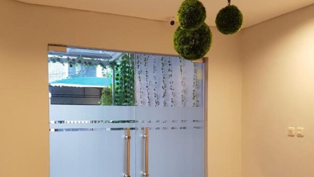 A modern room with a glass door, a flat floor, and a ceiling with recessed lighting. - City Style Residence (Jakarta)