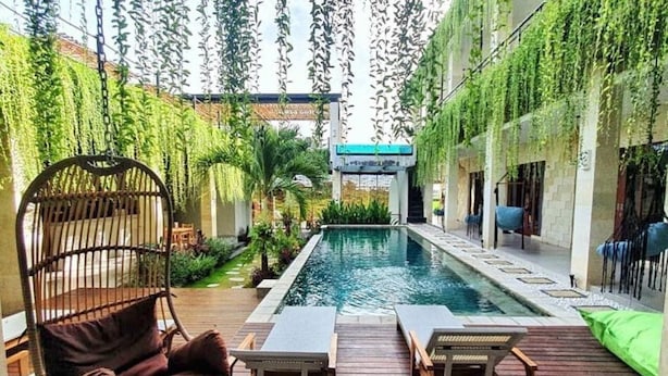 A pool area with a hanging chair, lounge chairs, and a small staircase leading to a covered area. - Canggu Hype (Canggu)