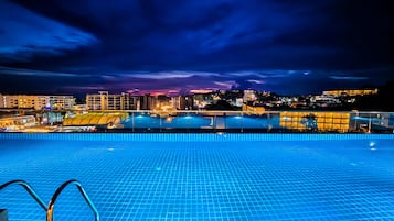 Una piscina al aire libre, tumbonas