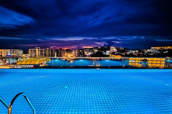Una piscina al aire libre, sillones reclinables de piscina