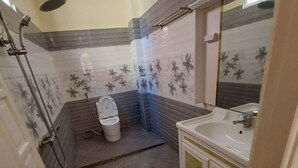 Ein Badezimmer mit Dusche, Toilette und Waschbecken.