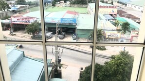 A view of a commercial area with various buildings, including a sports field and a covered parking area.