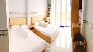 Habitació d'hotel amb dos llits, una taula de treball i una cadira.