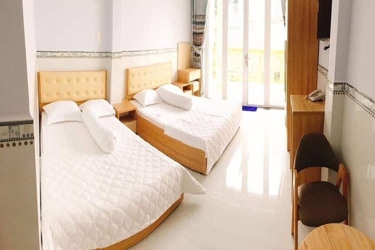 Una habitación de hotel con dos camas, un escritorio y una silla.
