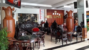 A hotel lobby with ornate furniture, a television displaying a guitar Spanish instrumental, and a sign for 'HOTEL KINGS 2'. - Kings 2 Hotel (Thong Nhat)