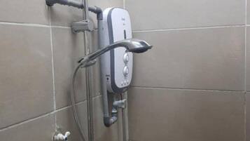 A shower with a handheld showerhead and a wall-mounted control panel.