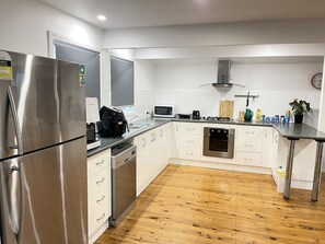 Prepare meals in a well-equipped kitchen with a refrigerator, dishwasher, and oven, plus ample counter space.