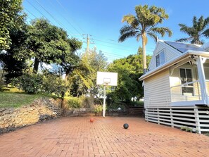 Enjoy the outdoor space with a basketball hoop, patio, and lush greenery.