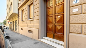 Un bâtiment doté d’une grande porte en bois, d’un panneau indiquant un parking (« P ») et d’un panneau de signalisation indiquant un arrêt (« STOP »).