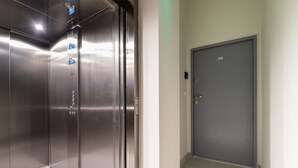 A modern elevator with stainless steel doors and a digital display.