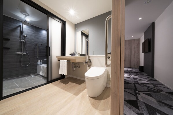 A modern bathroom with a glass-enclosed shower, a toilet, and a sink with a mirror. - Hotel JAL City Toyama (Toyama)