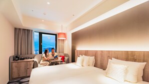 A hotel room with a large bed, a desk, and a view of the city. - Hotel JAL City Toyama (Toyama)