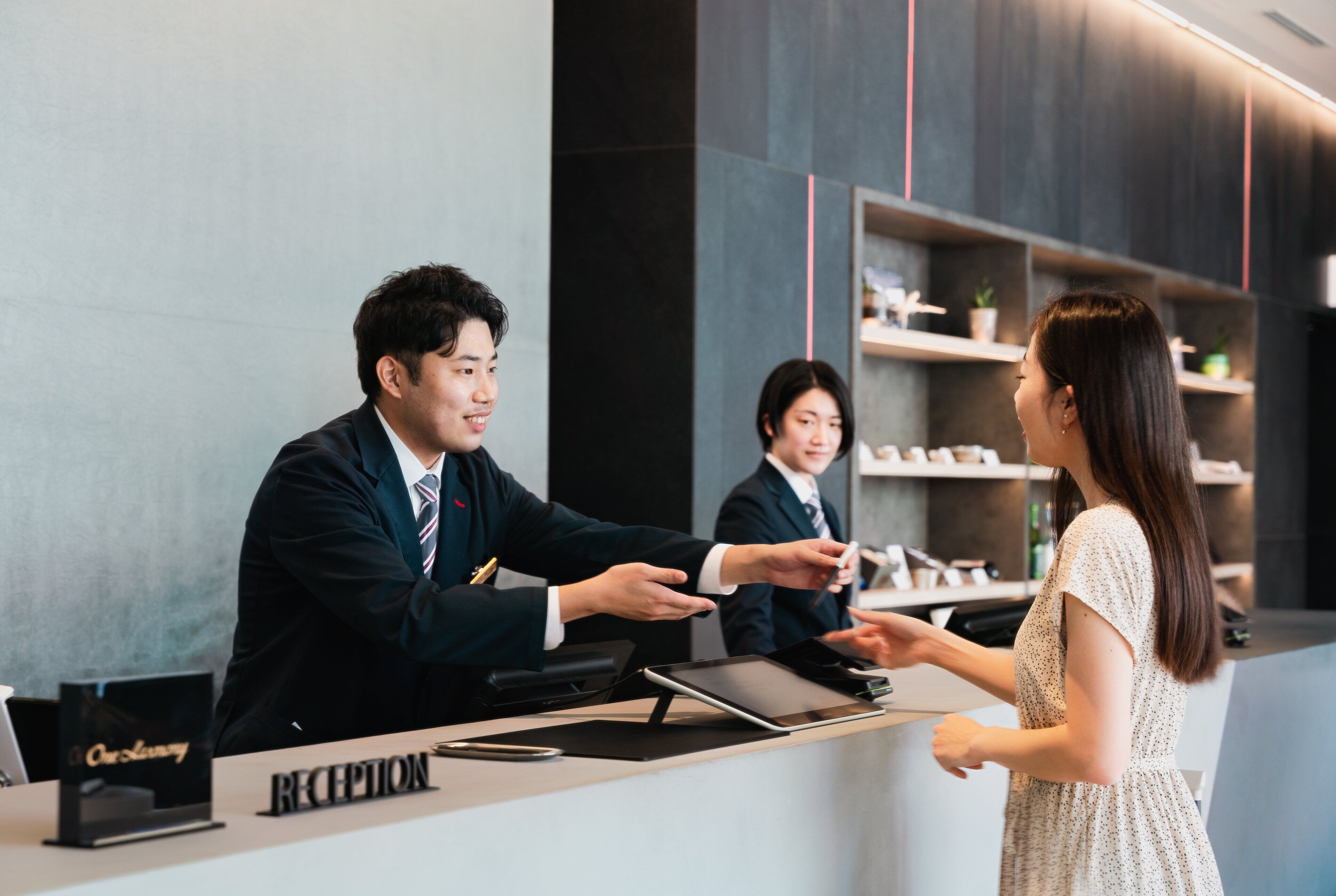 A reception desk with a sign reading "RECEPTION" and a tablet on it.