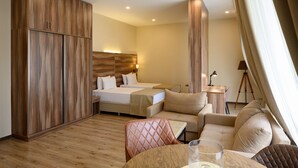 A hotel room with a wooden wardrobe, two beds, a sofa, a small table, and a tripod lamp. - Nacho Hotel Yerevan By One (Yerevan)