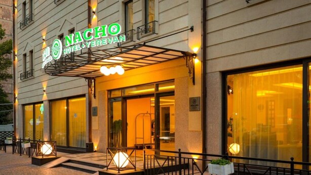 A hotel entrance with a neon sign, large windows, and outdoor lighting. - Nacho Hotel Yerevan By One (Yerevan)
