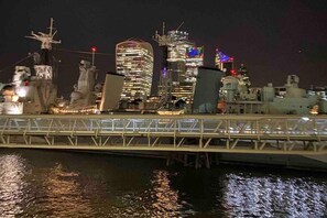 A nighttime cityscape with illuminated buildings and a bridge over water. - Remarkable Apartment Near London Tower Bridge (London)