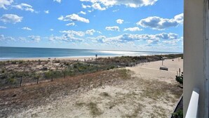 Vista de playa con arena, una cerca y un banco.