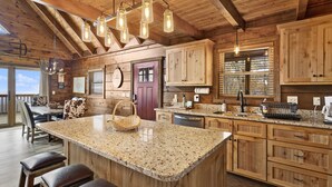 A spacious kitchen with a large island, wooden cabinets, and a farmhouse-style design. - Upscale Cabin With Stunning Views (Boone)