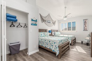A bedroom with two beds, a closet, and a window with blinds.